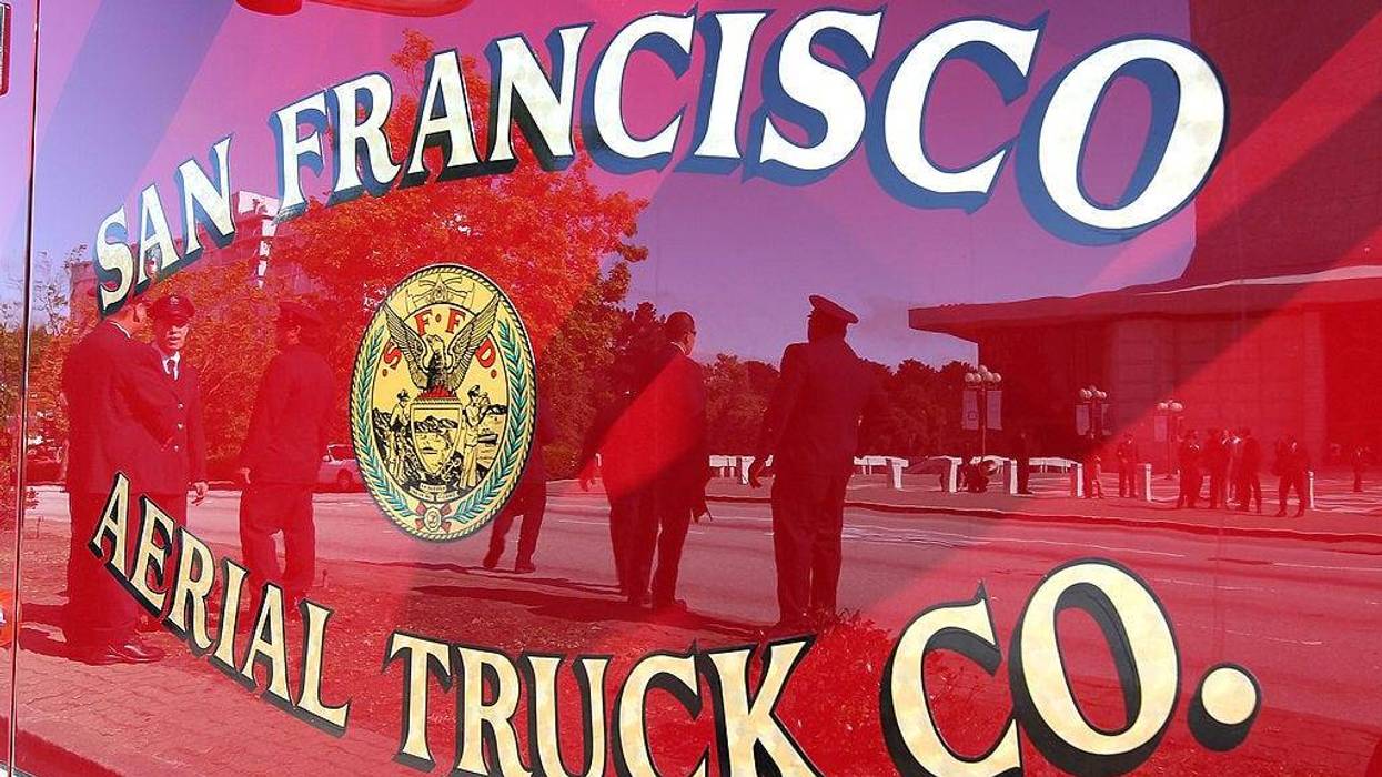 San Francisco firefighters are seen reflected in the door of a San Francisco fire truck June 10, 2011 in San Francisco, California.