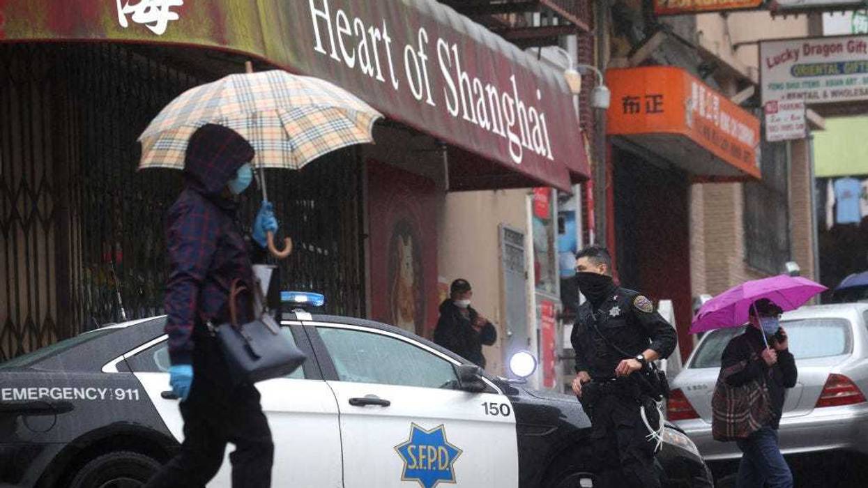 San Francisco police officer William Ma stands guard on a street corner in Chinatown on March 18, 2021 in San Francisco, California.