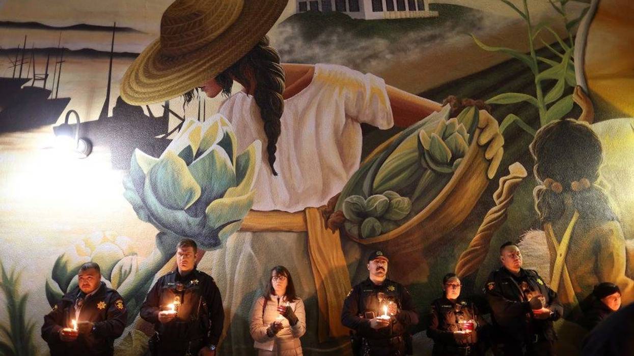 San Mateo County sheriff deputies hold candles during a candlelight vigil for the victims of the recent mass shooting in Half Moon Bay on January 27, 2023 in Half Moon Bay, California.