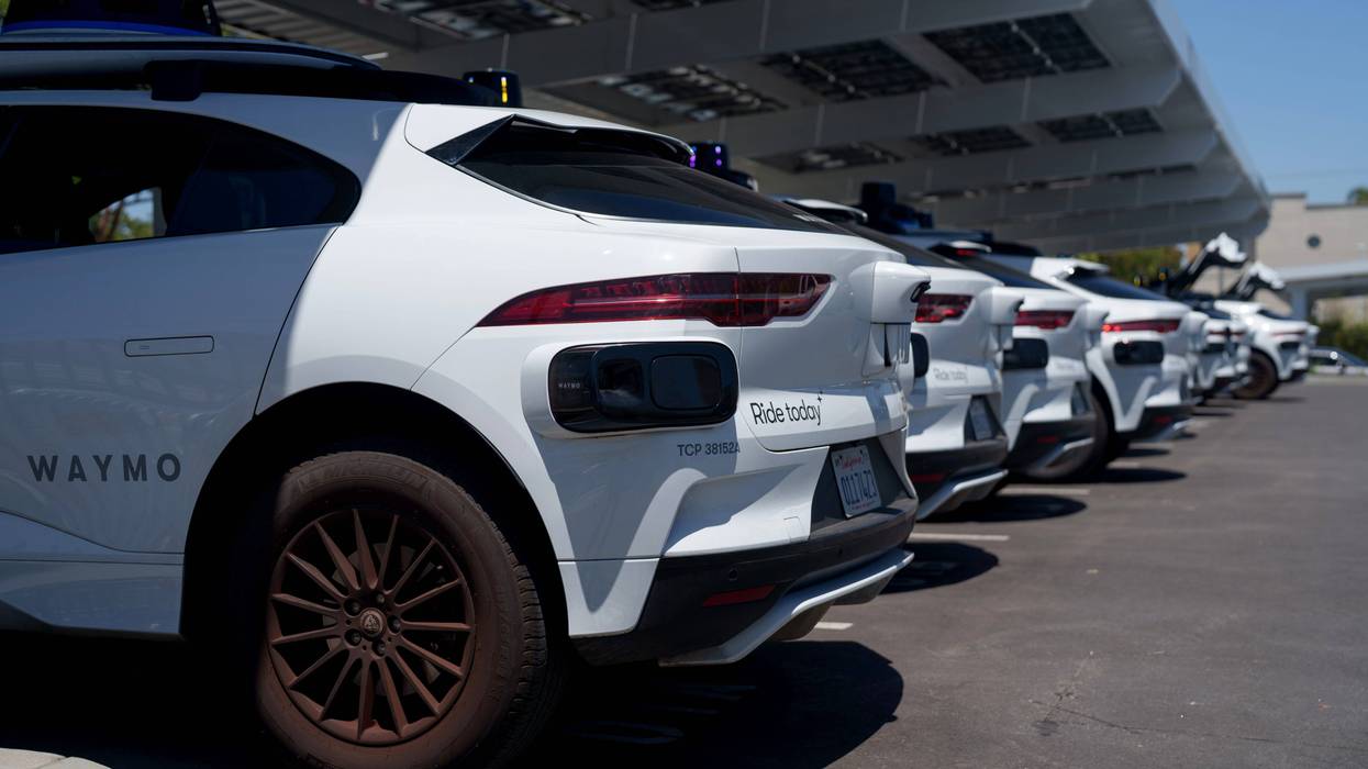 SANTA MONICA, CALIFORNIA - MAY 14: Waymo vehicles charge at a charging station on May 14, 2025 in Santa Monica, California. Waymo, owned by Alphabet, is recalling more than 1,200 self-driving vehicles to update software to address risks of collisions with roadway barriers after U.S. safety investigators opened a probe.