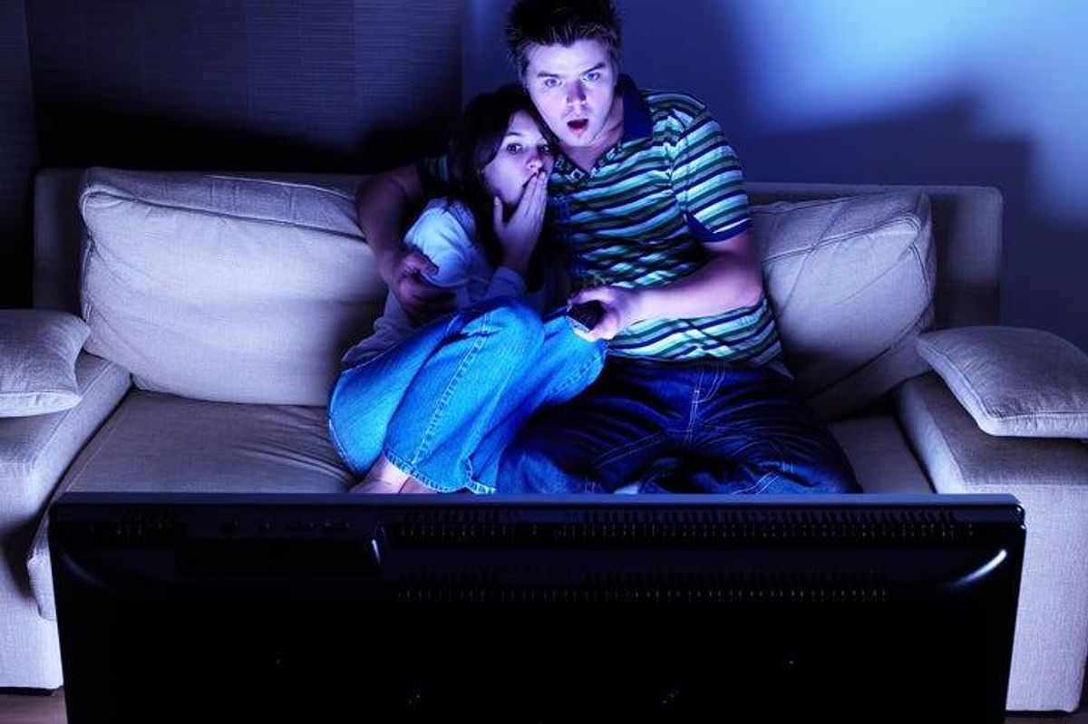 Scared couple watching television