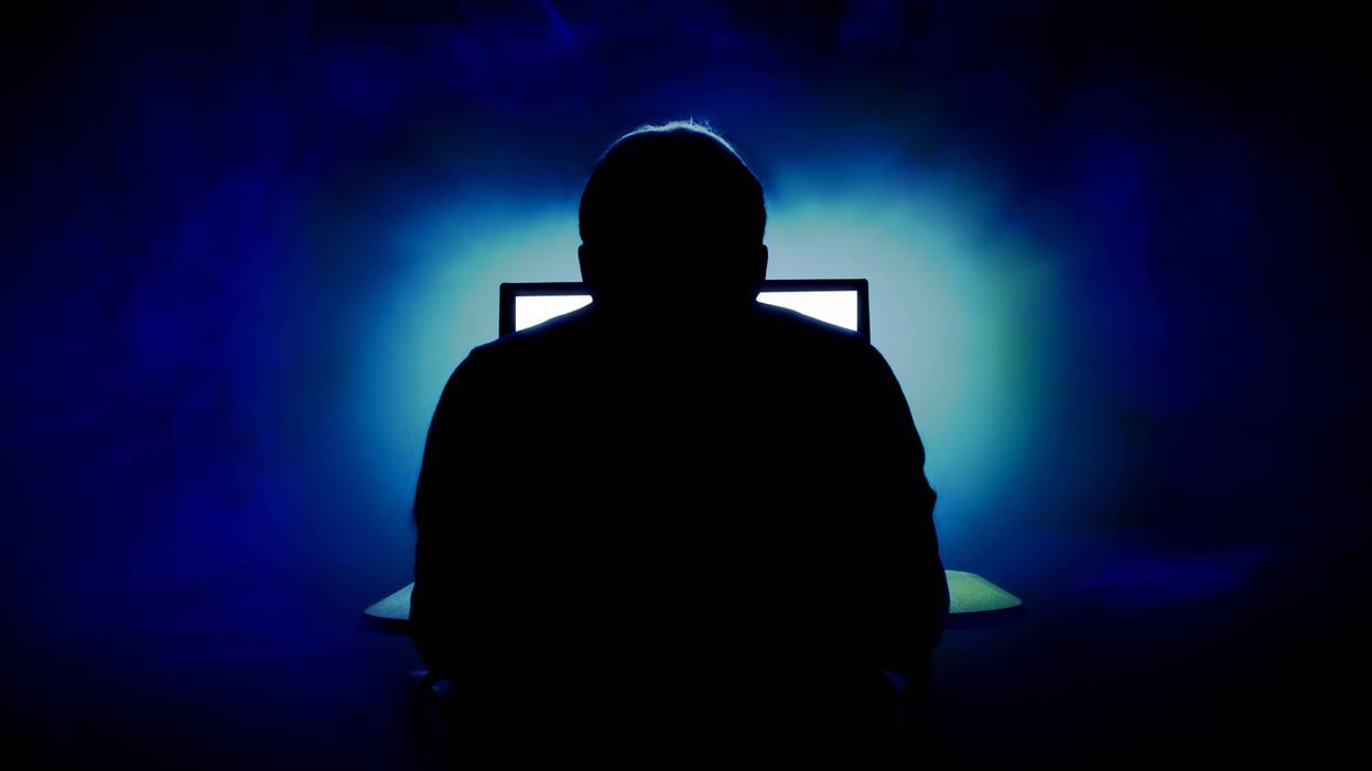 Scary man in front of screen, back turned to camera