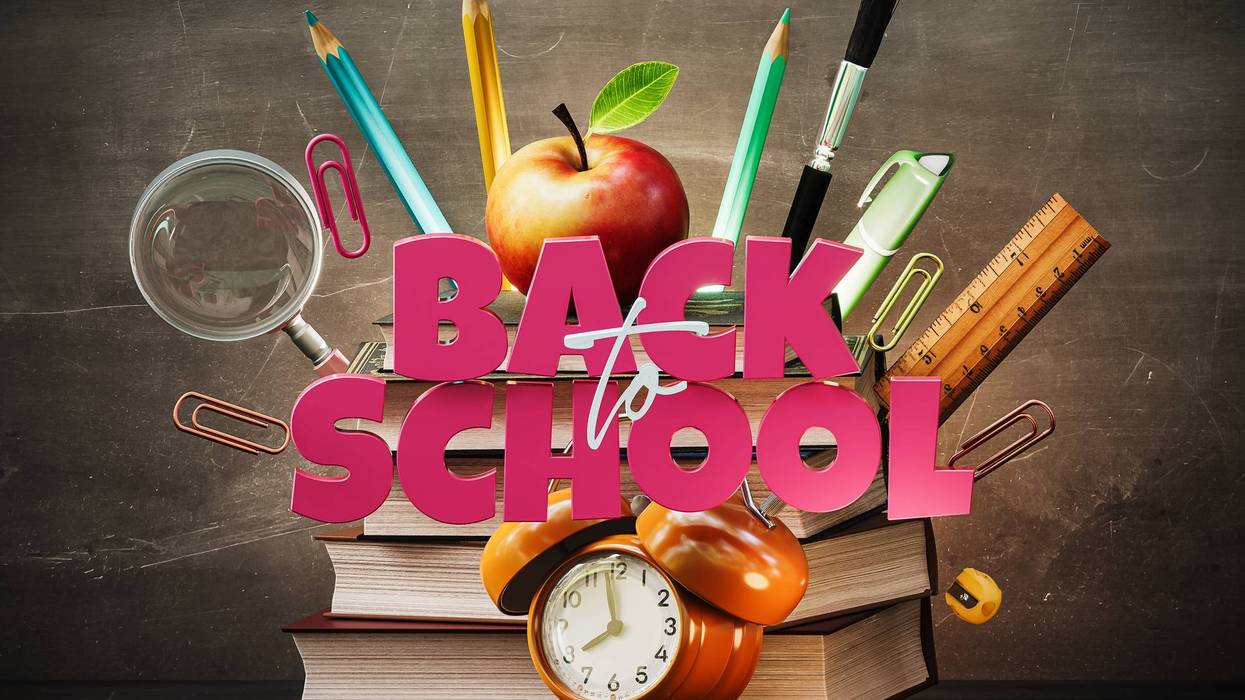 School accessories with books and Back To School text on blackboard background.