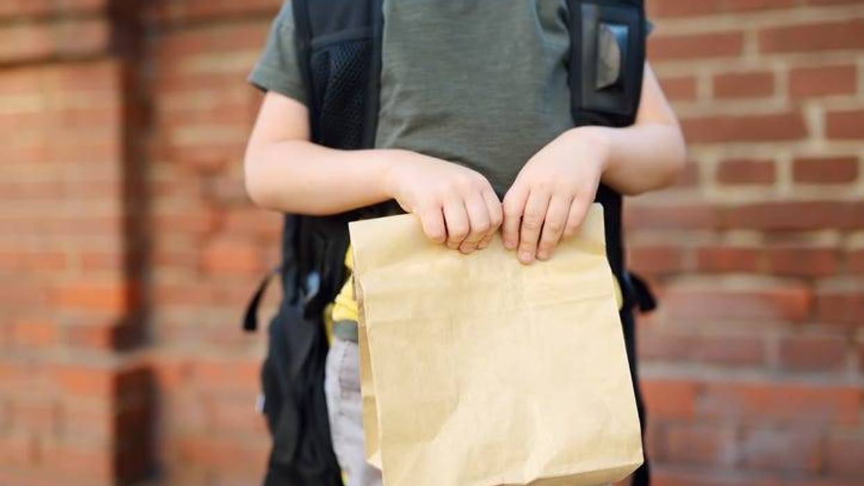 School age child holding a lunch.