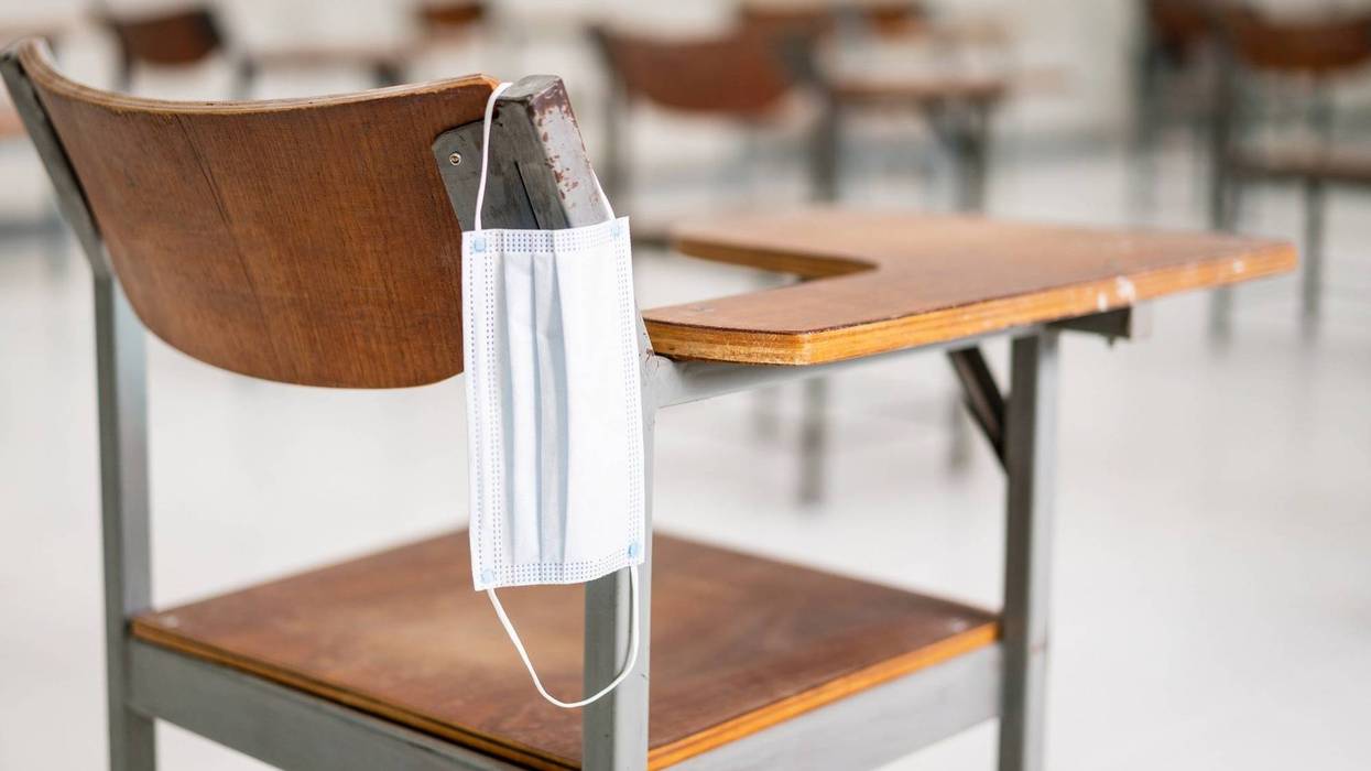 School classroom with desks, chairs and a COVID-19 mask