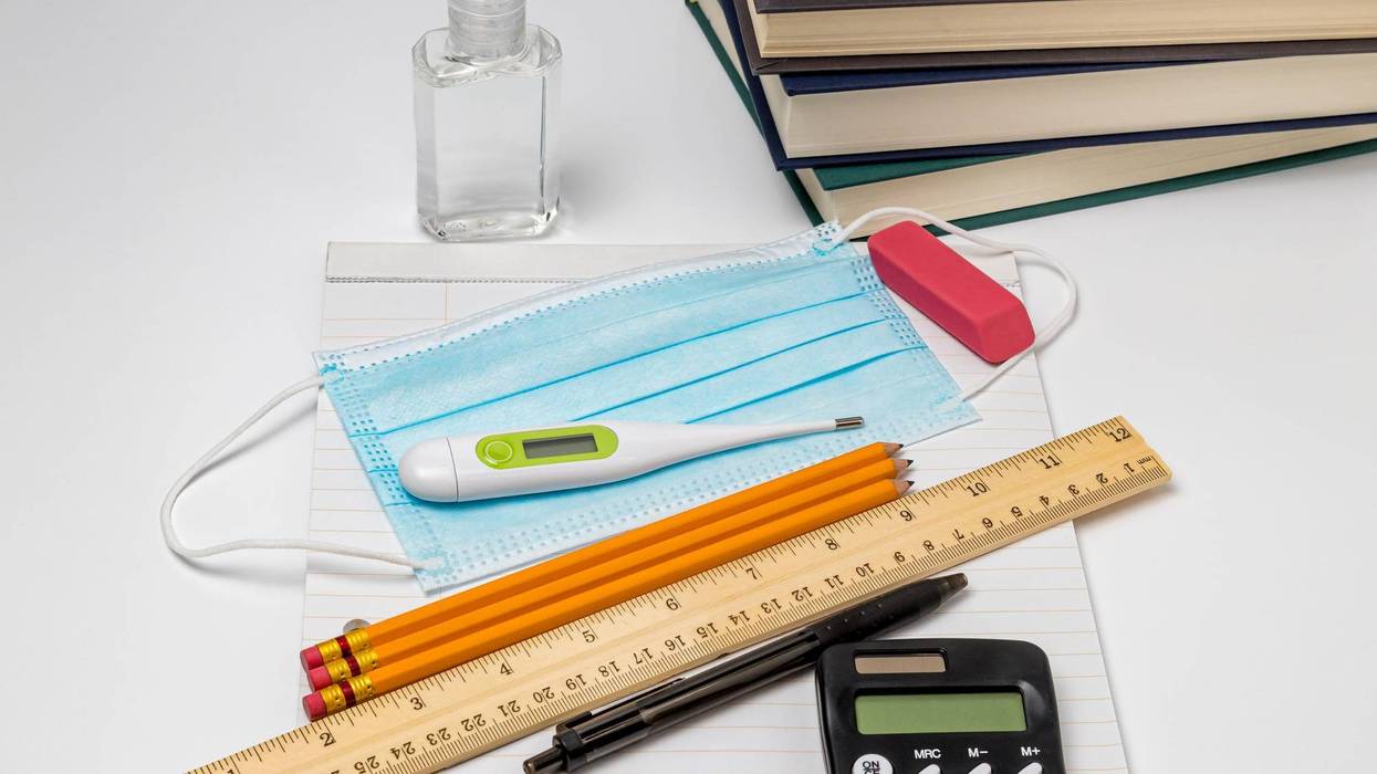 School supplies, face mask covering, hand sanitizer and thermometer. Concept of school reopening, new normal during Covid-19 coronavirus pandemic - stock photo