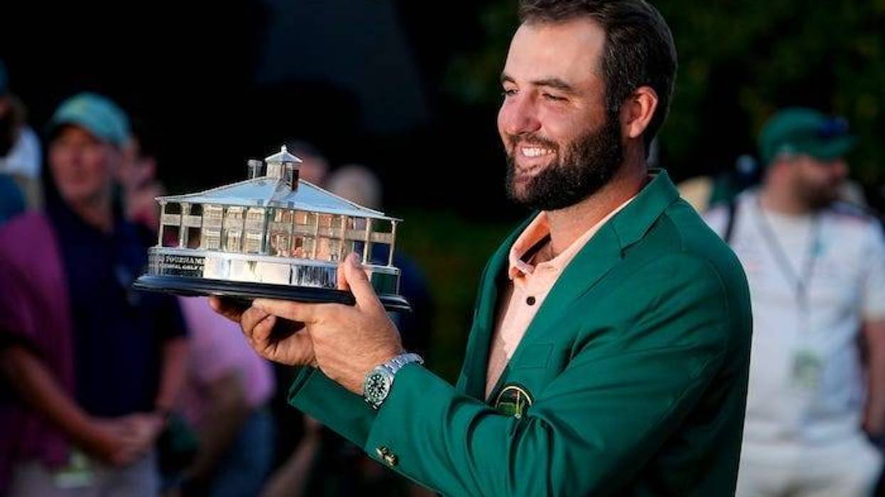 Scottie Scheffler holds up his trophy at the green jacket ceremony after winning the Masters Tournament