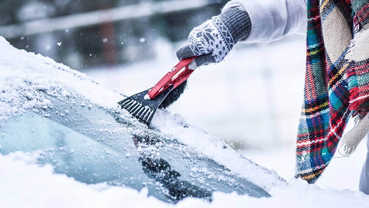 Scraping snow and ice from windshield