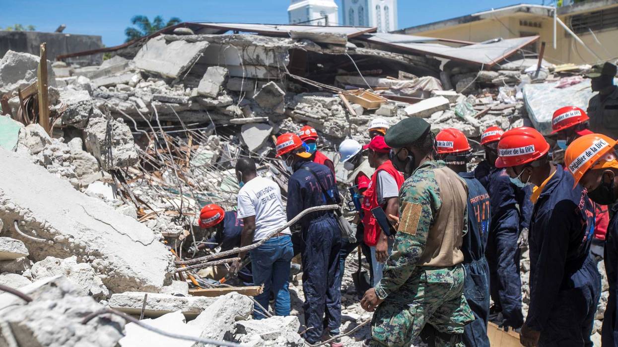 Search and rescue workers at the scene of a collapsed building in Les Cayes, Haiti, on Saturday