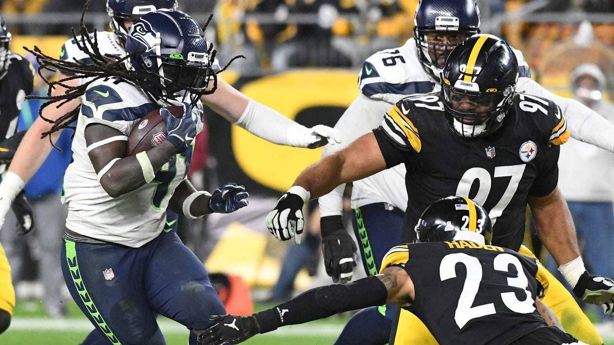 Seattle Seahawks running back Alex Collins (41) is slowed by Pittsburgh Steelers Joe Haden (23) and Cameron Heyward (97)