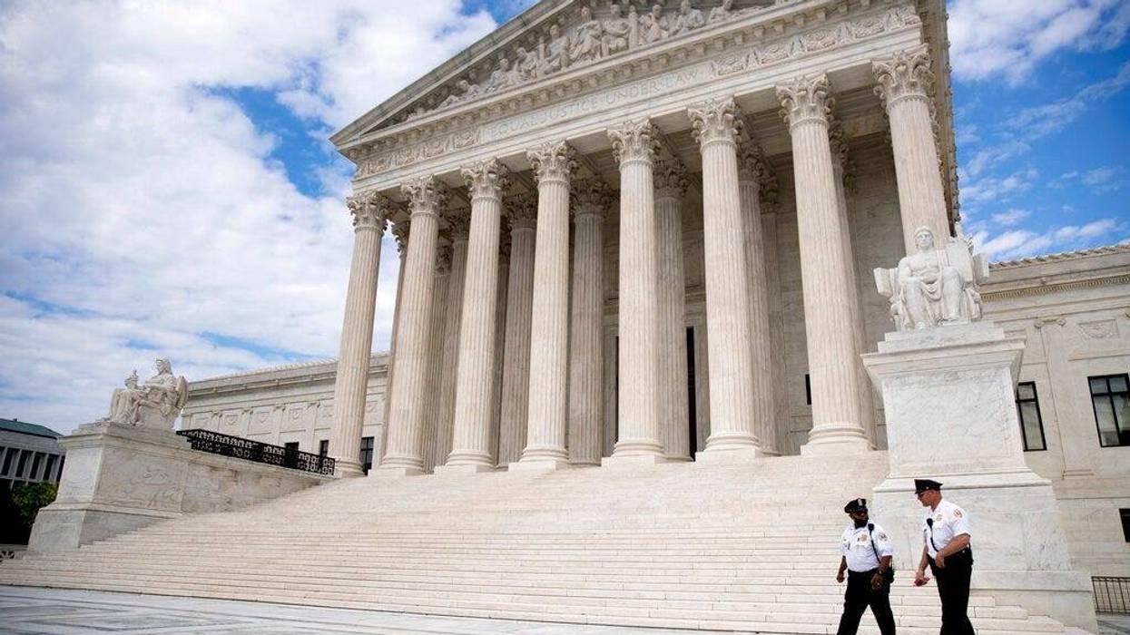 Security officers, one wearing a mask, walk in front of the Supreme Court, Thursday, May 14, 2020, in Washington. (AP Photo/Andrew Harnik)