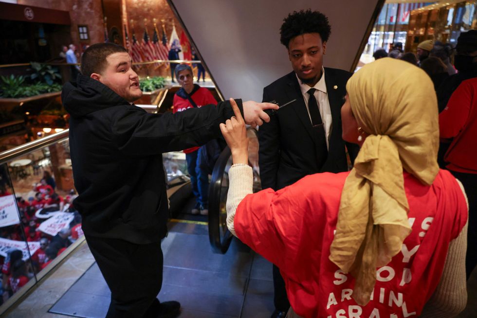 Security personnel with Trump Tower confront a demonstrator from the group, Jewish Voice for Peace, as they protest inside Trump Tower in support of Columbia graduate student Mahmoud Khalil, Thursday, March 13, 2025, in New York