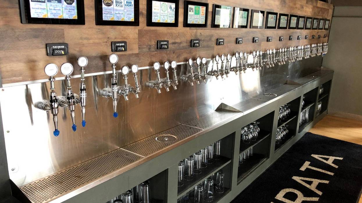 Self-serve taps for beer and cider are seen at a bar