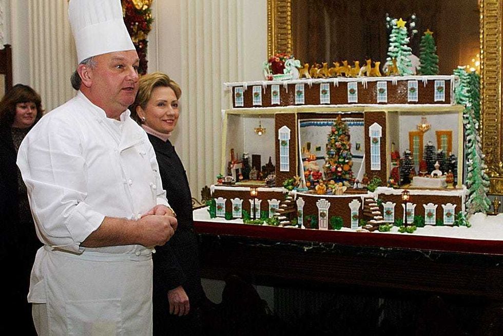 Senator-elect First Lady Hillary Rodham Clinton listens to Chef Roland Mesnier explain how a gingerbread house was made December 4, 2000 in the State Dining Room of the White House in Washington, DC. (Photo by Alex Wong/Newsmakers)