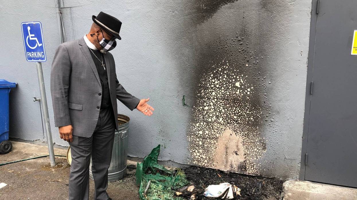 Senior Pastor Mike McBride shows the spot outside his church that was damaged by a suspected arson fire Wednesday.