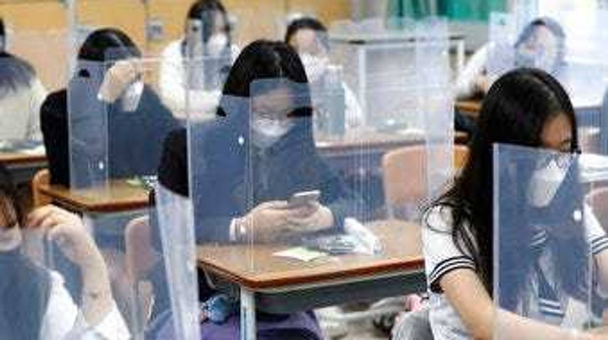 Senior students wait for class to begin with plastic boards placed on their desks at Jeonmin High School in Daejeon, South Korea, Wednesday, May 20, 2020. (Kim Jun-beom/Yonhap via AP)