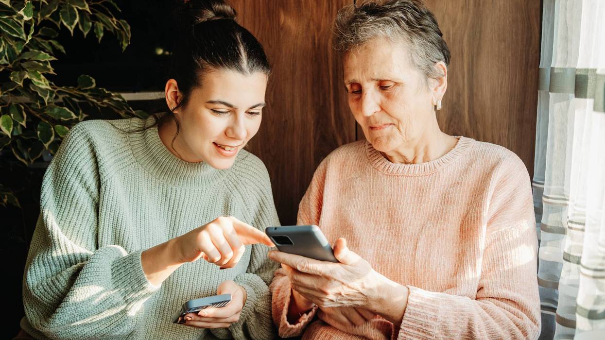 Senior woman and her granddaughter use cellphone to send text messages sms