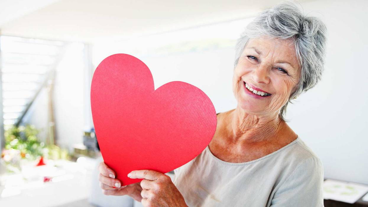 Senior woman holding a large paper heart