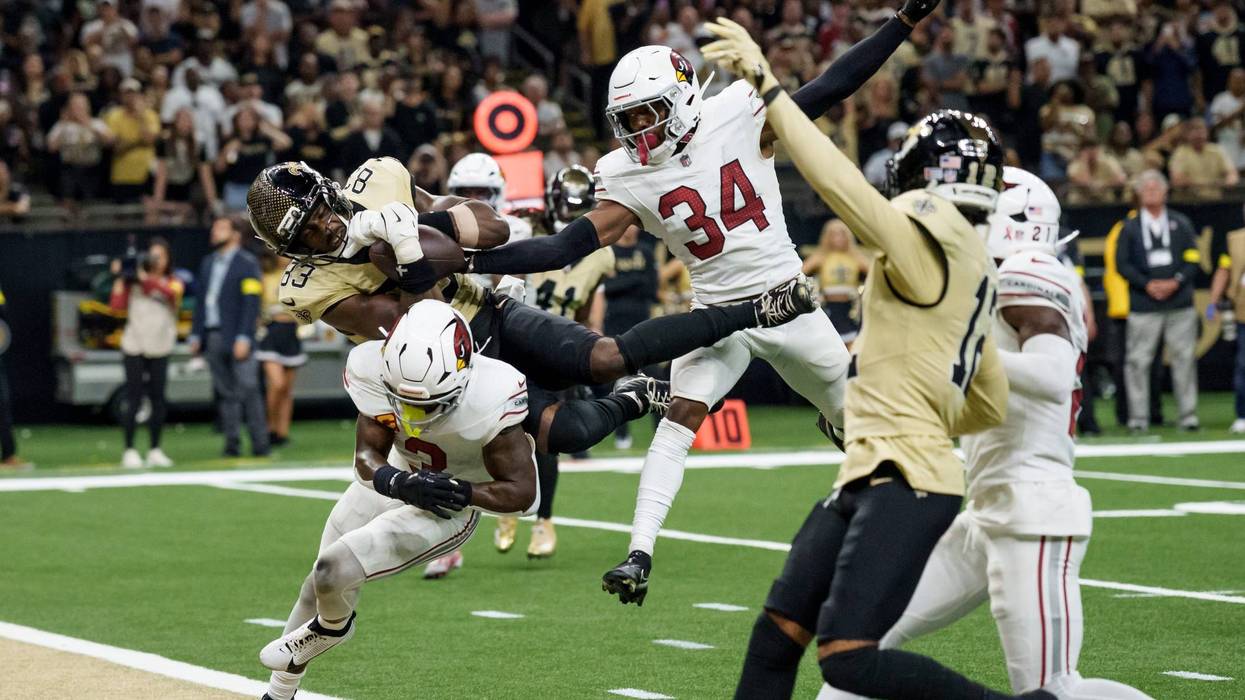 Sep 7, 2025; New Orleans, Louisiana, USA; New Orleans Saints tight end Juwan Johnson (83) grabs a pass in the end zone but Arizona Cardinals safety Jalen Thompson (34) knocks the ball loose in for an incomplete pass during the fourth quarter at Caesars Superdome.