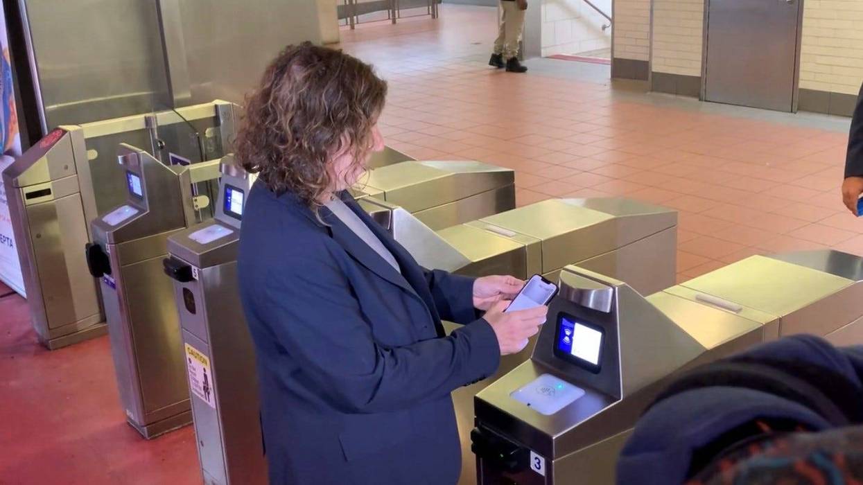 SEPTA General Manager Leslie Richards demonstrates the transit agency's new contactless pay-by-phone fare system at the City Hall Broad Street Line station.