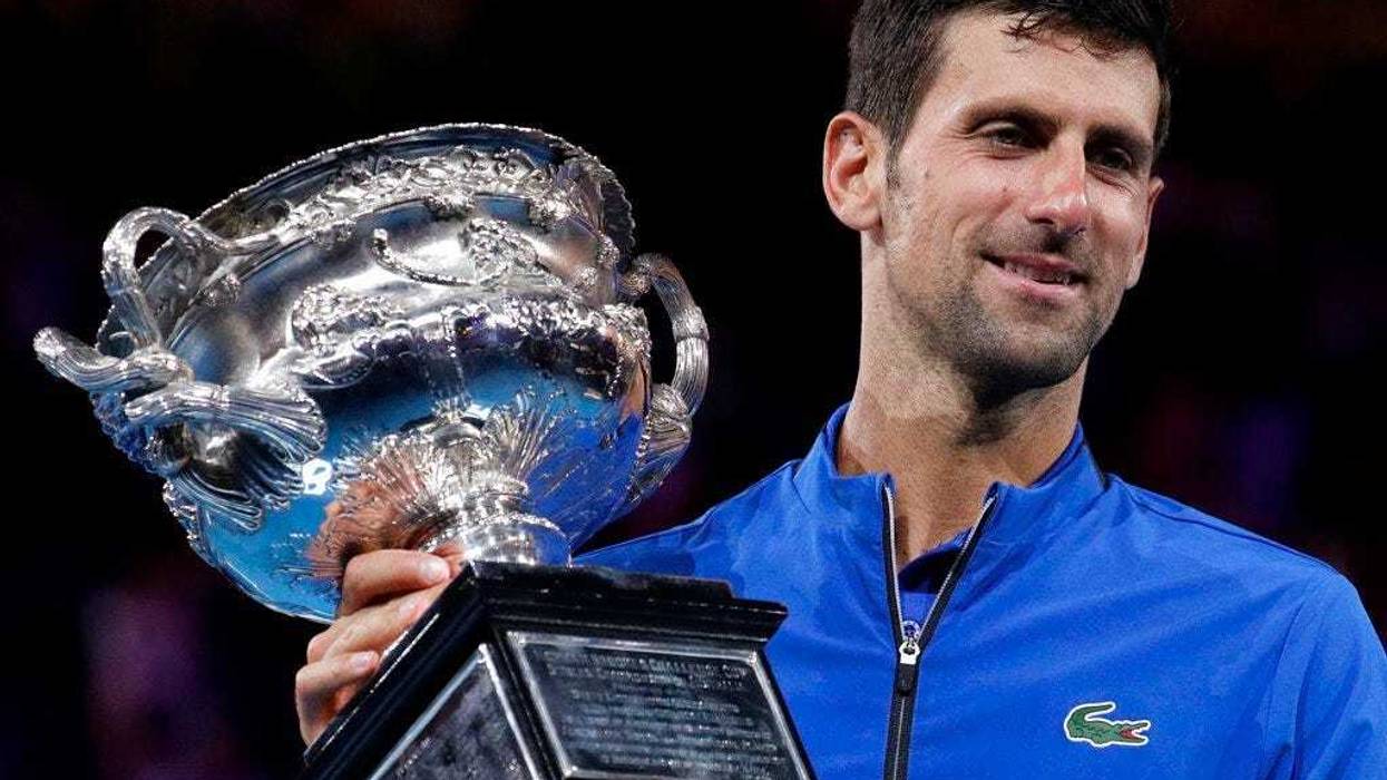Serbia's Novak Djokovic holds his trophy after defeating Spain's Rafael Nadal in the men's singles final at the Australian Open tennis championships