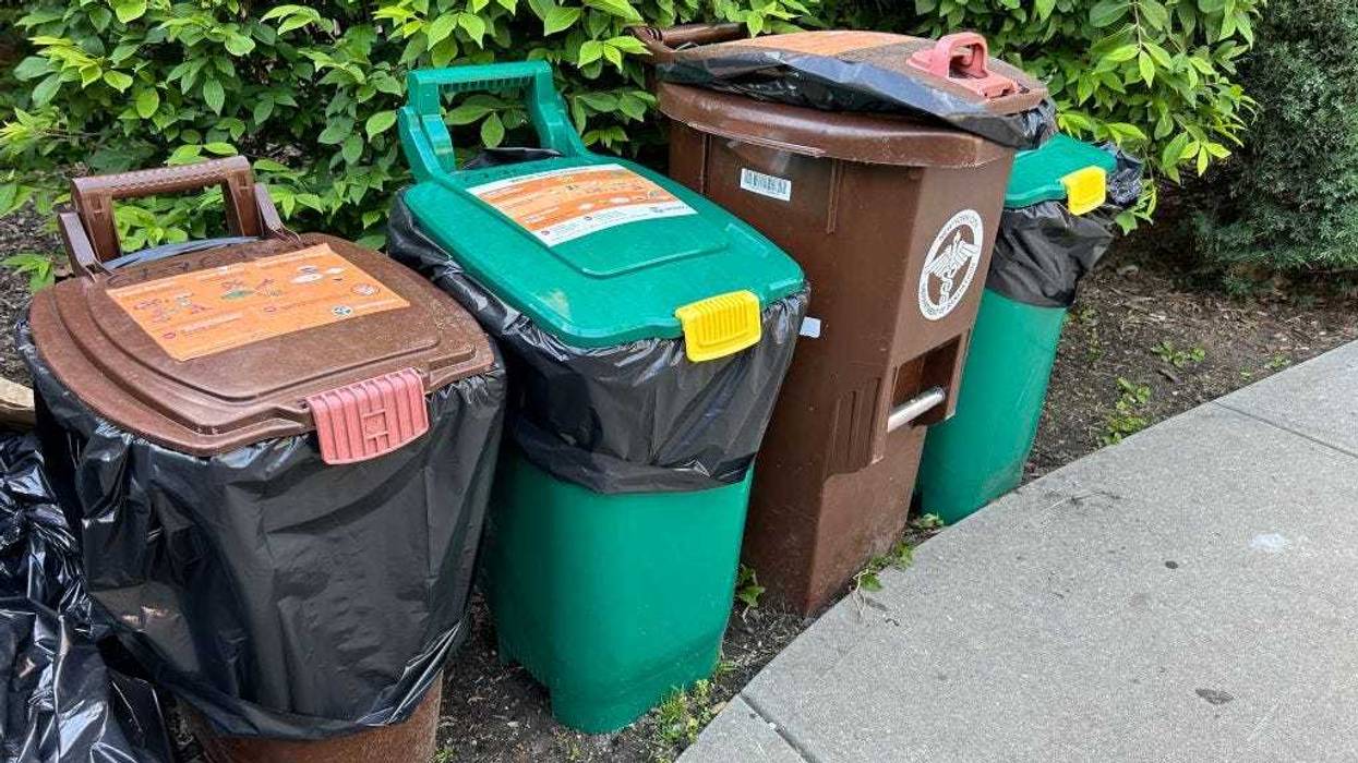 Several city Compost, food scrap collection bins lined up on sidewalk, Queens, New Yor