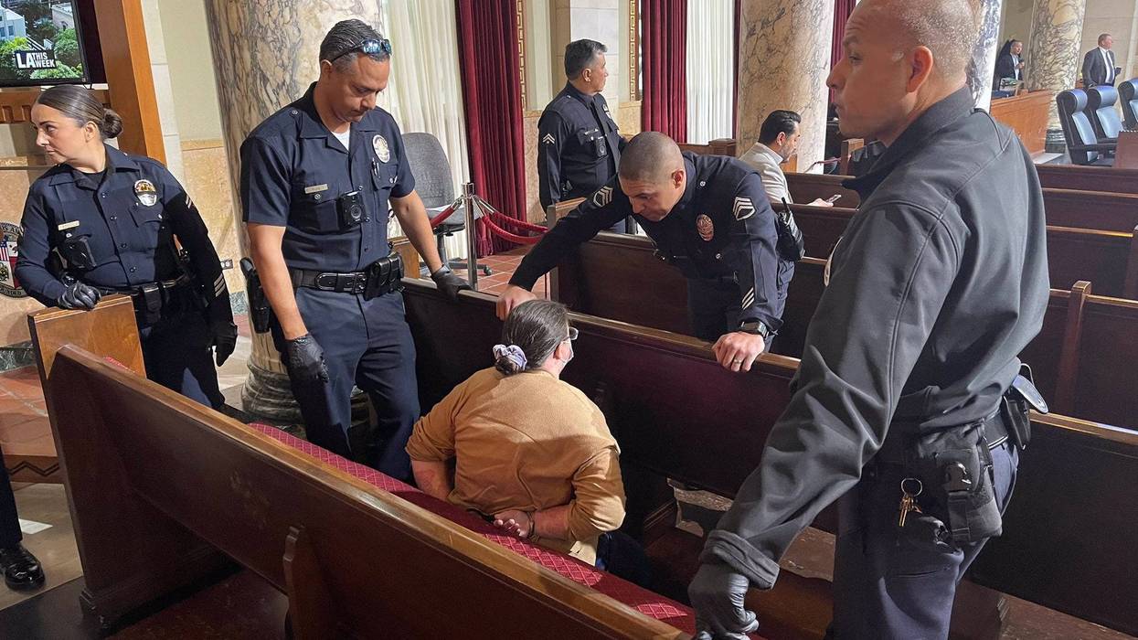 several police officers surround woman in city council chamber