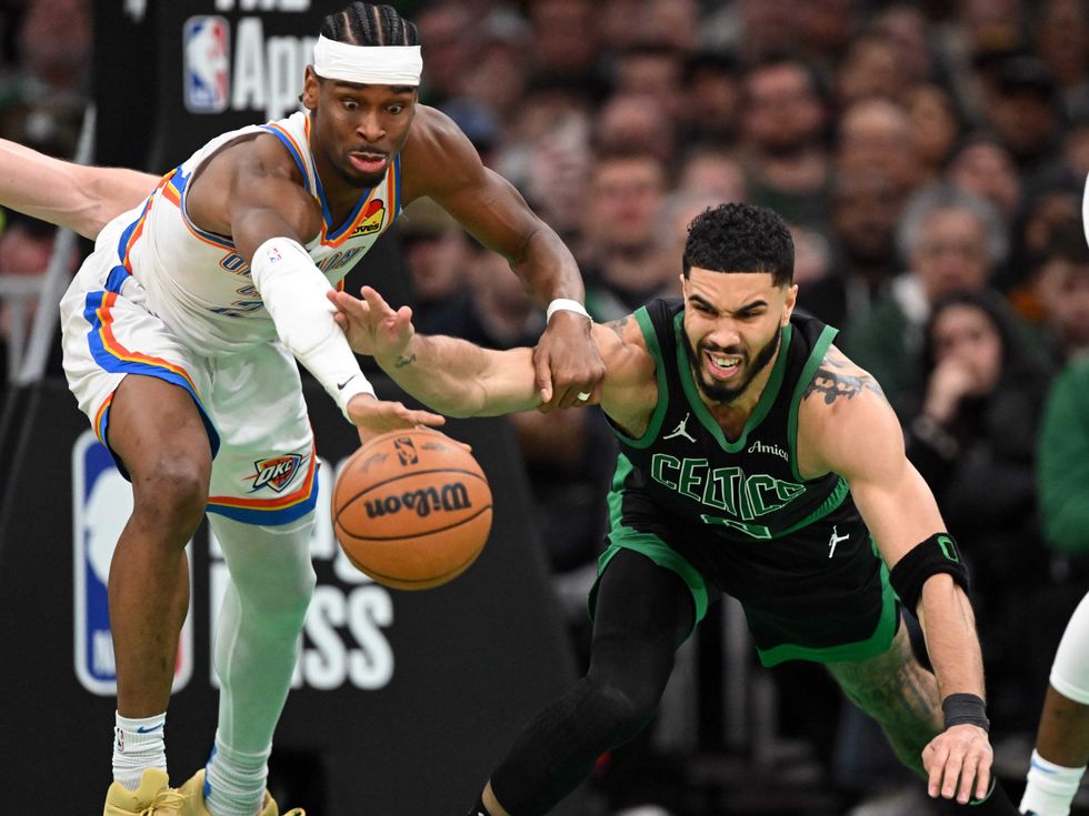 Shai Gilgeous-Alexander #2 of the Oklahoma City Thunder and Jayson Tatum #0 of the Boston Celtics reach for the ball during the fourth quarter at the TD Garden on March 12, 2025 in Boston, Massachusetts.
