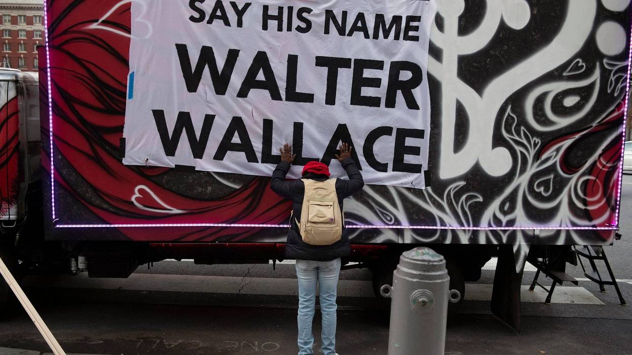 Sheila Rhames rests her hands on a banner honoring Walter Wallace Jr. in Philadelphia