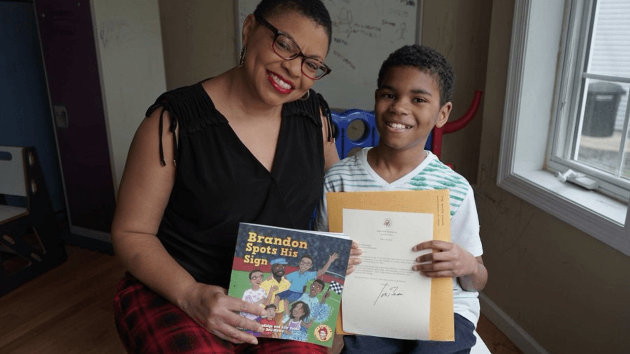 Sheletta Brundidge (L) and her son Brandon Brundidge pose with the children's book she wrote for him and to raise awareness for autism.