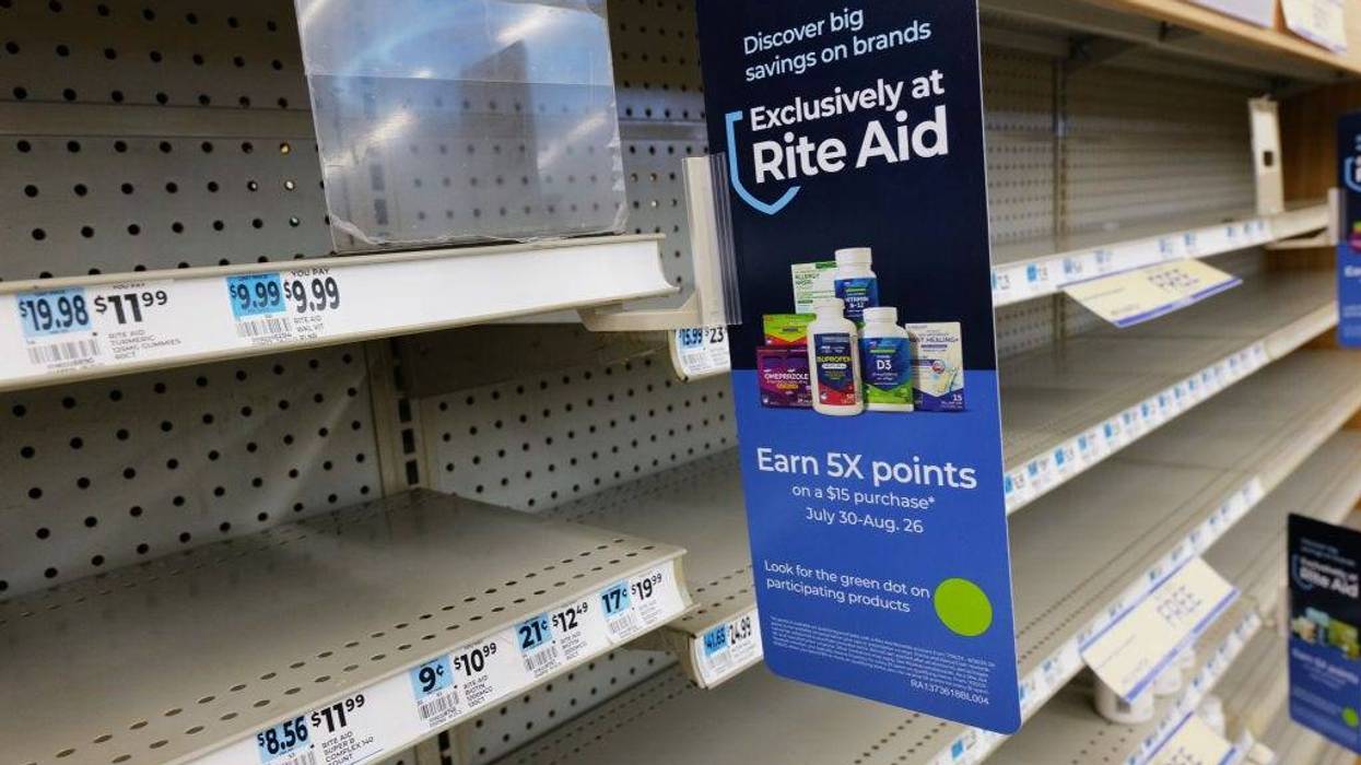 Shelves, many bare of merchandise, stand in a Rite Aid store