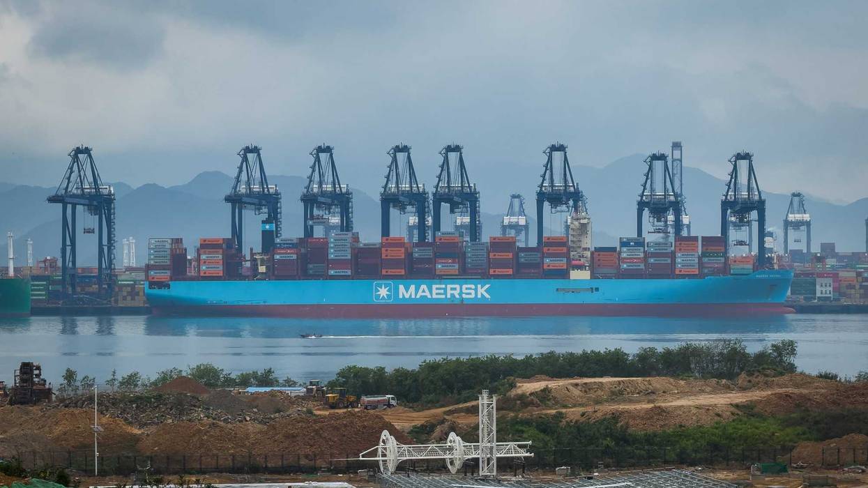 SHENZHEN, CHINA - APRIL 12: A large container vessel operated by Danish shipping giant Maersk is docked at the Yantian International Container Terminal, with gantry cranes unloading containers amid port expansion construction in the foreground, on April 12, 2025 in Shenzhen, China. China has imposed a new round of retaliatory tariffs on U.S. imports, raising duties to 125% in response to the latest escalation by the United States, which increased tariffs on Chinese goods to 145%. The growing trade tensions have further impacted China's export sector, affecting key industries such as logistics, manufacturing, and cross-border e-commerce. The measures are part of Beijing's broader strategy to counter rising economic pressure and defend its trade interests. (Photo by Cheng Xin/Getty Images)