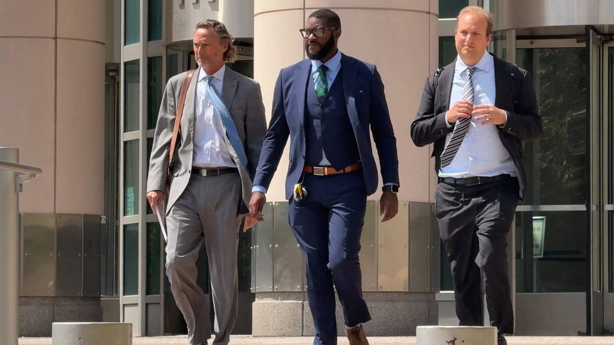 Sheriff Alfred Montgomery, flanked by his lawyers, exits the federal courthouse after his initial indictment