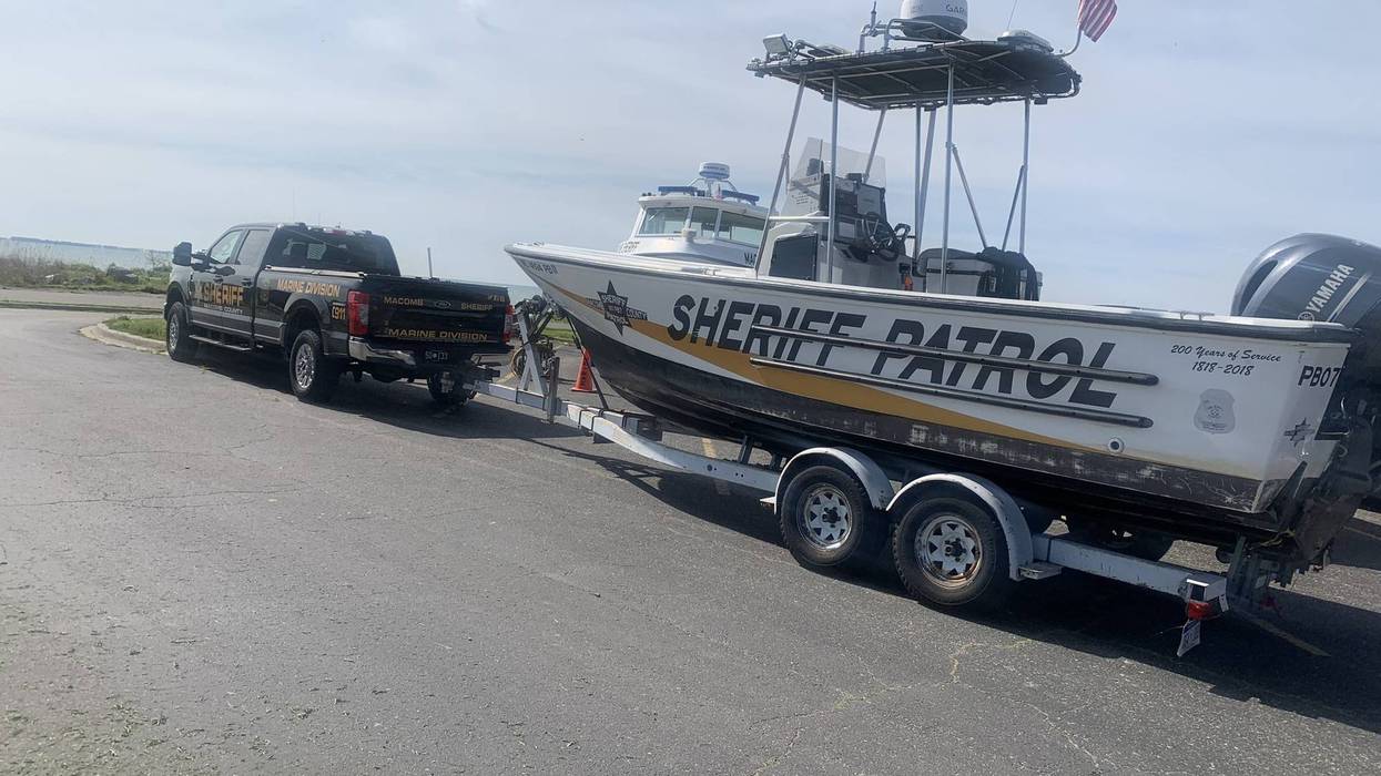 Sheriff Marine Division truck towing a patrol boat with an American flag.