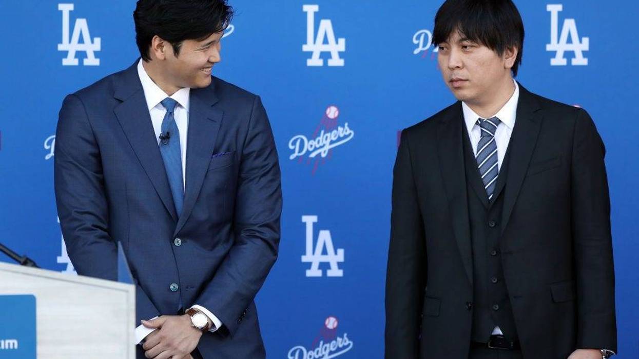 Shohei Ohtani speaks with his interpreter Ippei Mizuhara prior to being introduced by the Los Angeles Dodgers at Dodger Stadium on December 14, 2023 in Los Angeles, California.