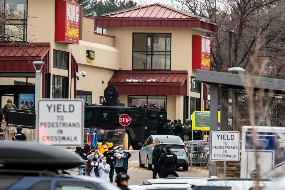 Shoppers are escorted out of a King Soopers grocery where a gunman opened fire on March 22, 2021 in Boulder, Colorado.