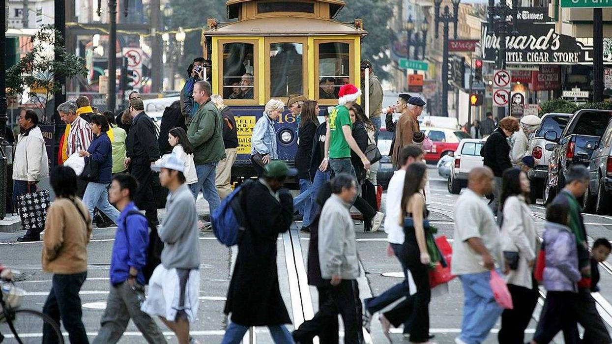 Shoppers pass in front of a cable car as they walk through the Union Square shopping district December 24, 2004 in San Francisco, California.