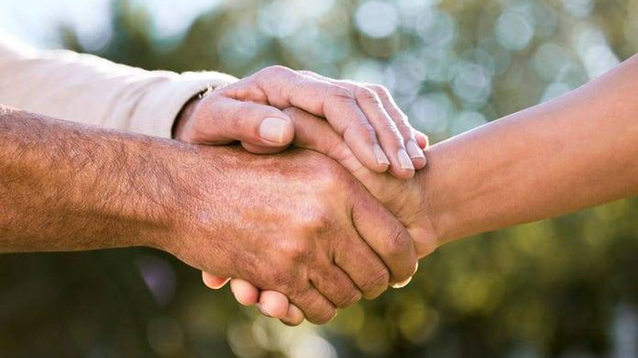 Shot of two unrecognizable men holding hands outdoors