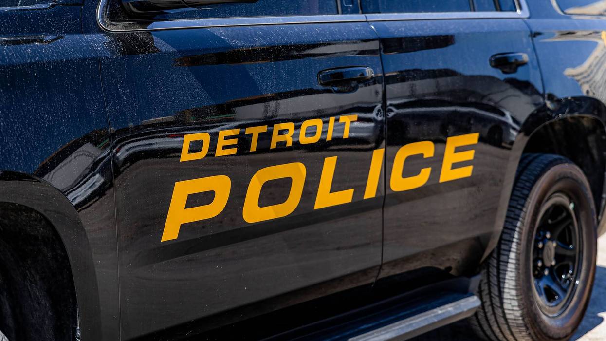 Side of a black Detroit Police vehicle with "DETROIT POLICE" in orange letters.