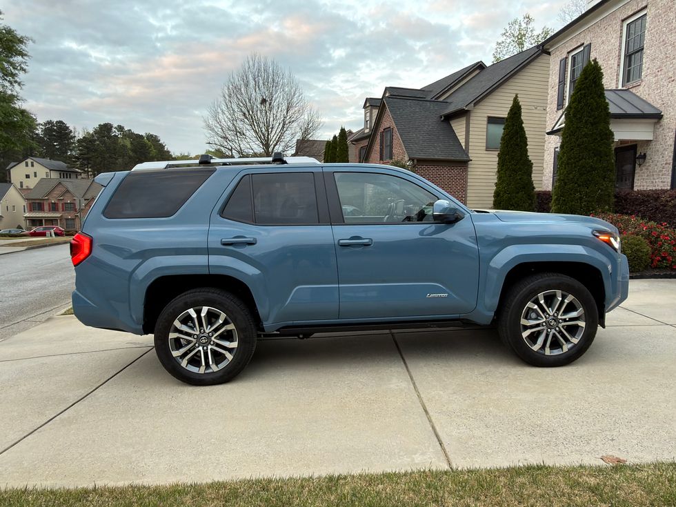 Side view of a blue Toyota Sequoia Limited SUV parked on a suburban driveway.