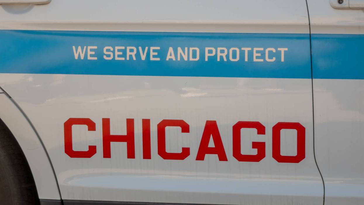 Side view of a marked Chicago police vehicle showing blue stripe, WE SERVE AND PROTECT and red CHICAGO lettering.