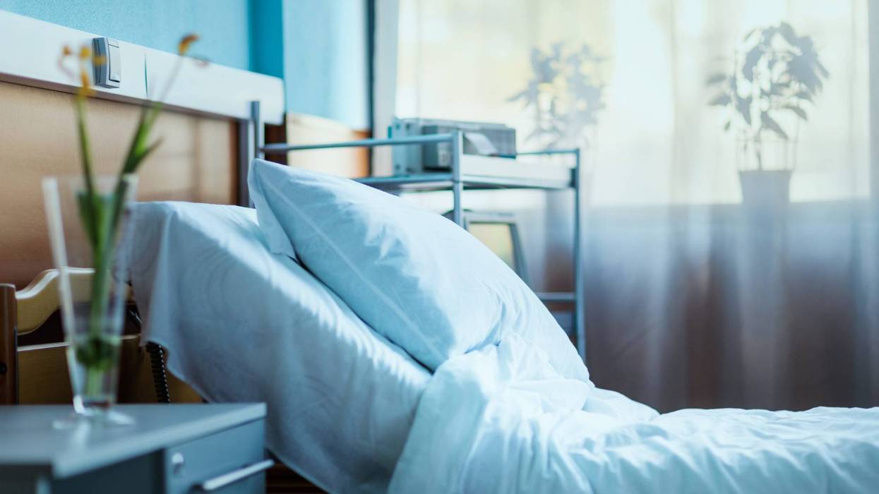 Side view of an empty hospital bed in a clinic chamber.