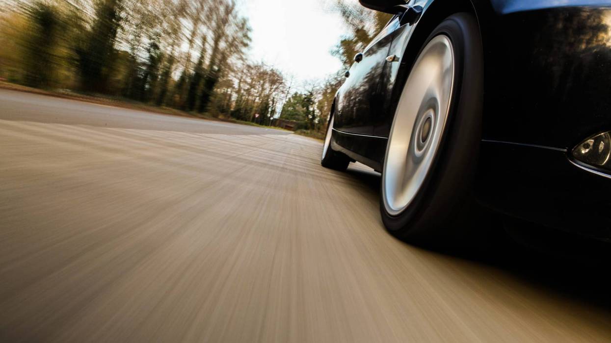 Side view of black car driving fast.