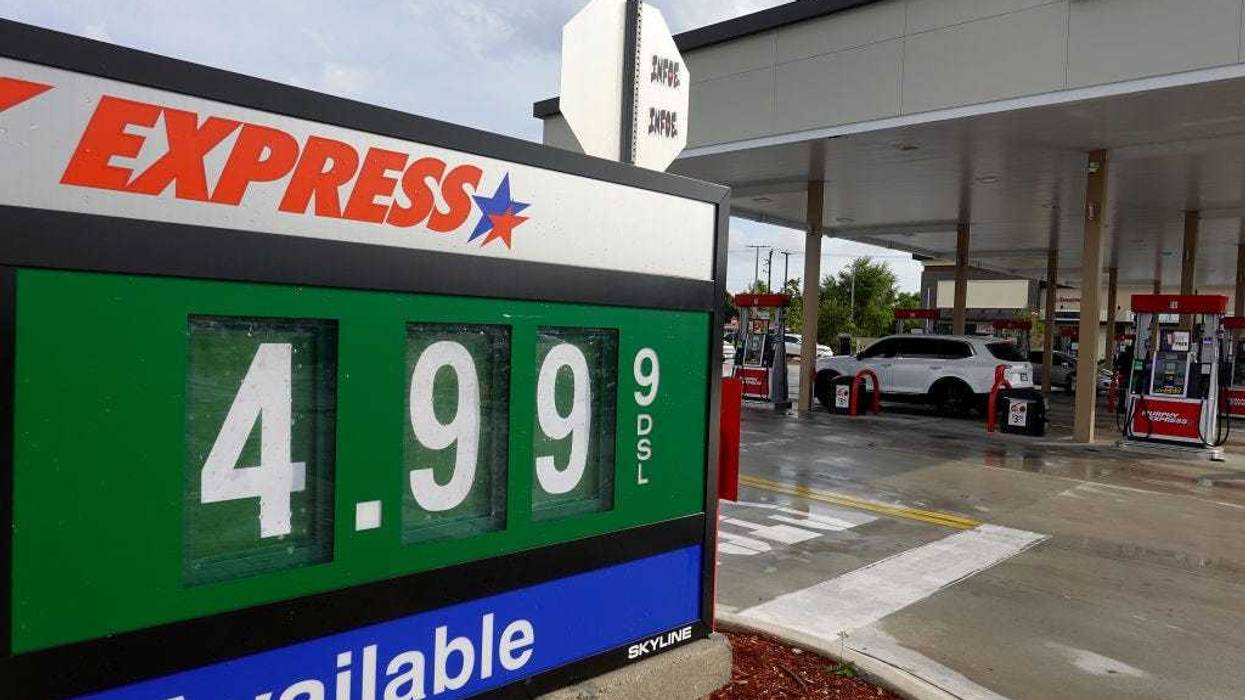 sign at a gas station shows $4.99 per gallon
