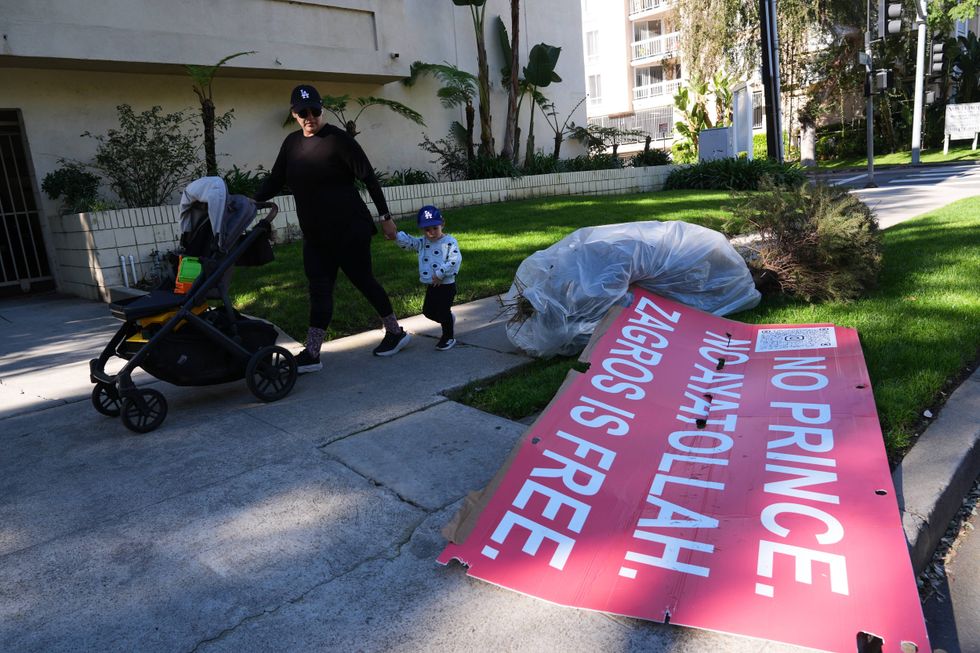 Signs from a Sunday protest, supporting protesters in Iran, are left on a sidewalk Monday, Jan. 12, 2026, in Los Angeles.
