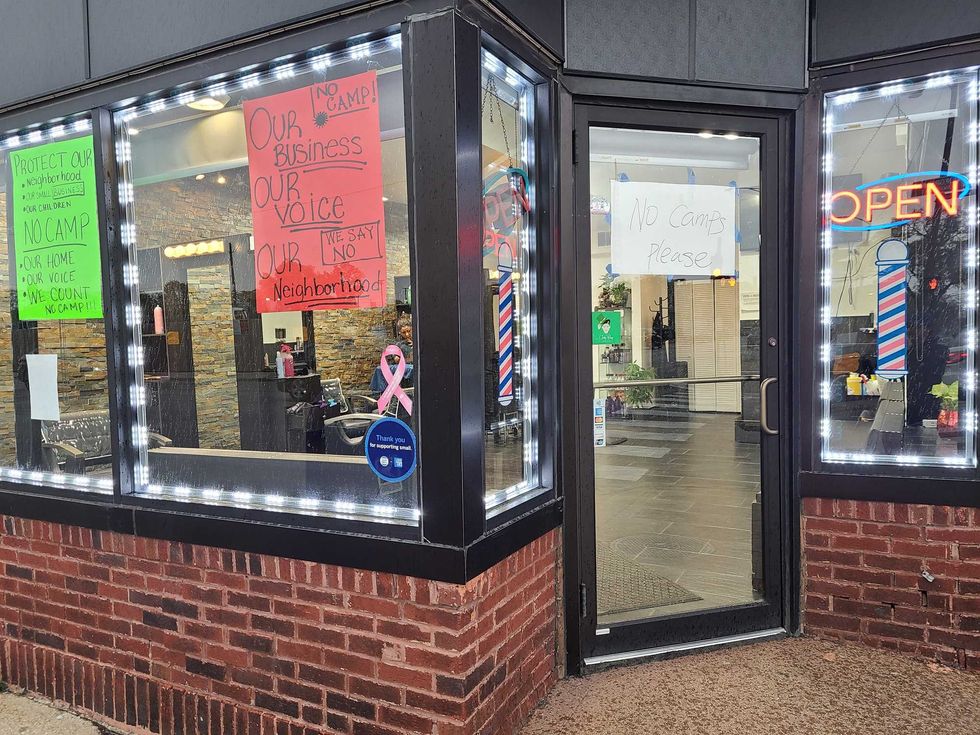Signs in a Brighton Park business voice opposition to a planned migrant tent encampment.