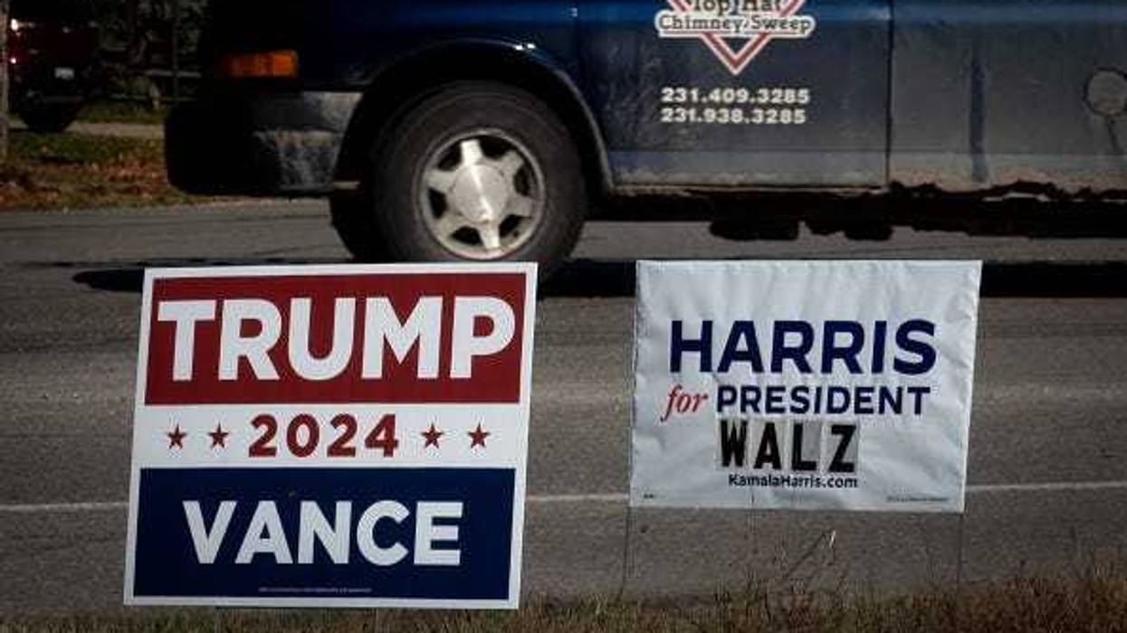 Signs showing support for both Democratic presidential candidate Vice President Kamala Harris and Republican presidential candidate former President Donald Trump sit along a rural highway on September 26, 2024 near Traverse City, Michigan.