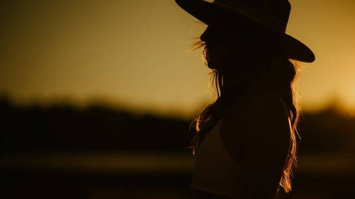 Silhouette of a woman wearing a cowboy hat