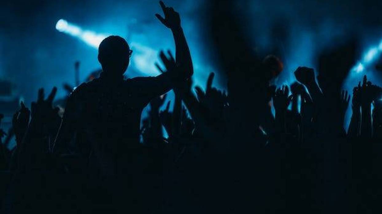Silhouette of man in front of a crowd at a concert