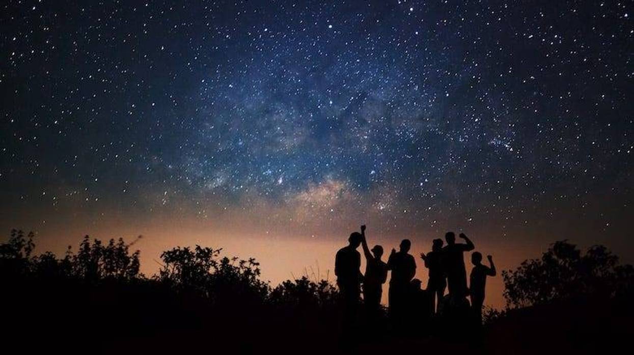 Silhouette of people stargazing at night